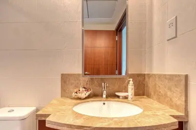 a bathroom with a sink and a toilet and a mirror at Stylish 2 Bedroom Opera View in Downtown Dubai SP2013 in Dubai
