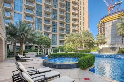 a courtyard with a pool and chairs and a building at Stylish 2 Bedroom Opera View in Downtown Dubai SP2013 in Dubai
