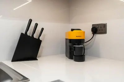 a coffee maker sitting on a counter next to a phone at BLVD - Steps from Dubai mall and Dancing Fountain in Dubai
