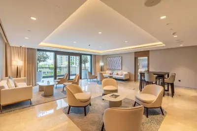 a lobby with a waiting area with chairs and a piano at BLVD - Steps from Dubai mall and Dancing Fountain in Dubai