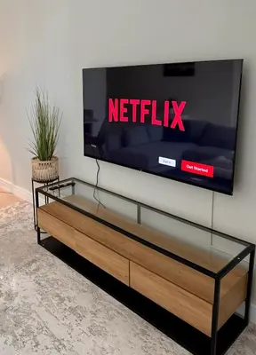 a tv with a netflix sign on a wall at Upgraded brand new apartment Downtown in Dubai