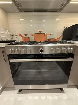 a kitchen with an oven with two pots on it at Upgraded brand new apartment Downtown in Dubai