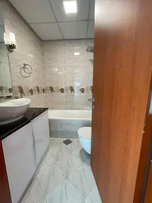 a bathroom with a sink and a toilet and a tub at Studio apartment in jumeriah village triangle district 2 in Dubai