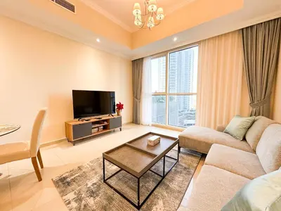 a living room with a couch and a tv at Elegant 1BR in Dunya Tower, Downtown Dubai 12AB10 in Dubai
