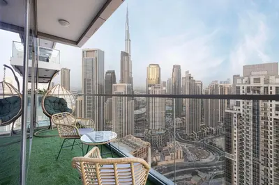 a balcony with chairs and a table and a view of the city at 5Star Stunning 2BR BURJ Khalifa View with Infinity Pool in Dubai