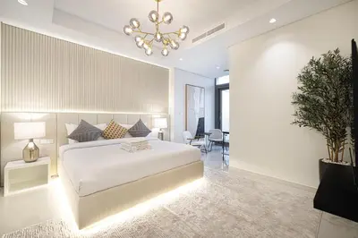 a bedroom with a white bed and a chandelier at 5Star Stunning 2BR BURJ Khalifa View with Infinity Pool in Dubai