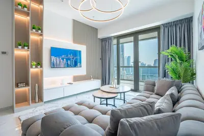 a living room with a large couch and a table at RH -Luxury 1BR, Large Balcony & High-End Interiors, Downtown in Dubai