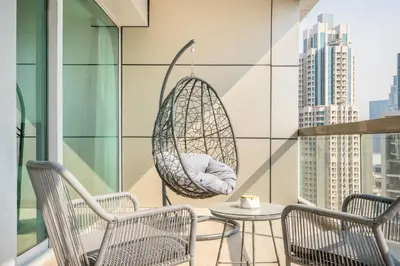 a swing hanging on a balcony with two chairs and a table at RH -Luxury 1BR, Large Balcony & High-End Interiors, Downtown in Dubai