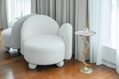 a white chair and stool next to a window at Clever Guest 028 Baltic in Dubai