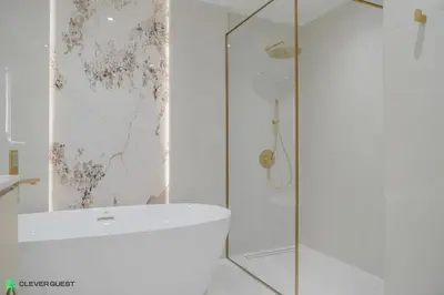 a bathroom with a shower and a white tub at Clever Guest 028 Baltic in Dubai