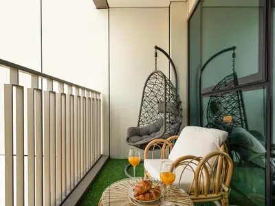 a balcony with a table and two glasses of orange juice at Amazing view Burj Khalifa 5mn Dubai Mall 2BDR in Dubai