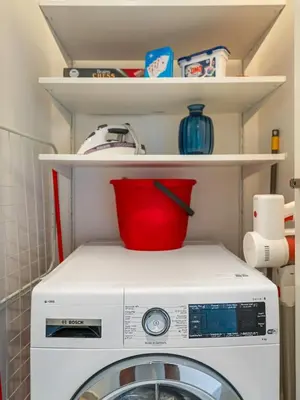a washing machine with a red bucket on top of it at Amazing view Burj Khalifa 5mn Dubai Mall 2BDR in Dubai