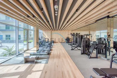 a gym with rows of treadmills and exercise equipment at Peaceful 1BR in Bella Rose Al Barsha South by Deluxe Holiday Homes in Dubai
