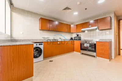 a large kitchen with wooden cabinets and a dishwasher at Stunning 2BR with Assistant Room in MAG 214, Jumeirah Lake Towers by Deluxe Holiday Homes in Dubai