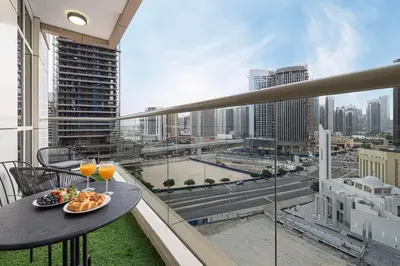 a balcony with a table with food and drinks on it at 3BR Luxury Escape at Mon Reve I Access to Pool and Gym in Dubai