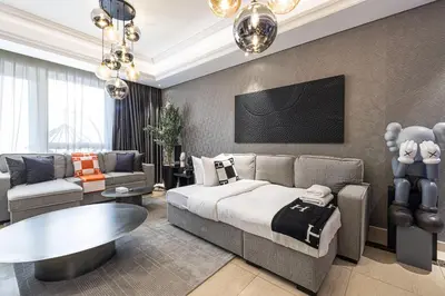 a bedroom with a bed and a couch and a table at 3BR Luxury Escape at Mon Reve I Access to Pool and Gym in Dubai