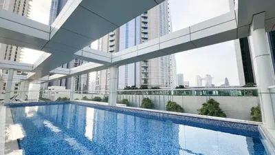 a swimming pool in a building with tall buildings at 3BR Luxury Escape at Mon Reve I Access to Pool and Gym in Dubai