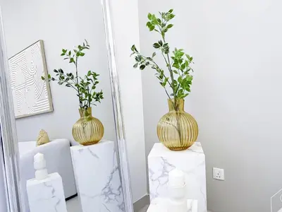 a mirror with two vases on top of white boxes at Luxury Design & Stunning Views in Dubai Hills in Dubai