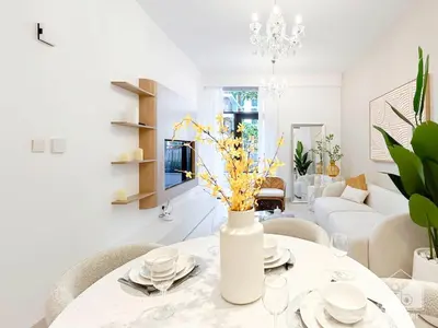 a white living room with a table with a vase of flowers at Luxury Design & Stunning Views in Dubai Hills in Dubai