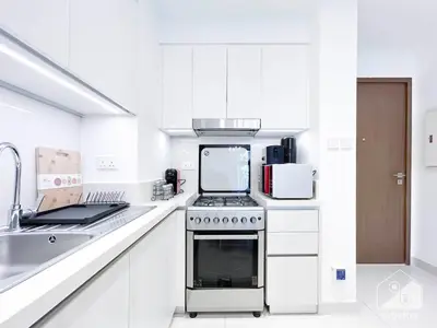 a white kitchen with a stove and a sink at Luxury Design & Stunning Views in Dubai Hills in Dubai