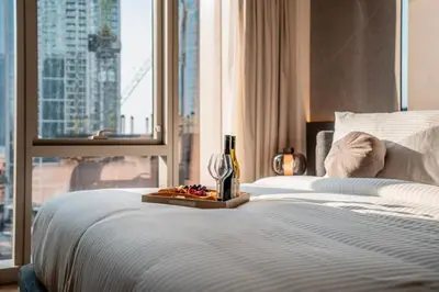 a bed with a bottle of wine and a tray of fruit at Luxury 1-Bedroom Holiday Apartment in Downtown Dubai I Walk to Dubai Mall and Fountains in Dubai