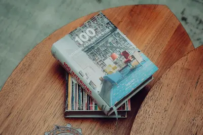 a stack of books sitting on top of a table at Elegant Studio Downtown 5 Minute Walk to Burj Khalifa & Dubai Mall in Dubai