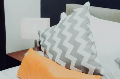 two gray and white pillows on a bed at Elegant Studio Downtown 5 Minute Walk to Burj Khalifa & Dubai Mall in Dubai