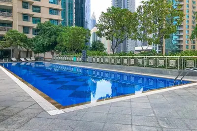 a large blue swimming pool in a city at Elegant Studio Downtown 5 Minute Walk to Burj Khalifa & Dubai Mall in Dubai