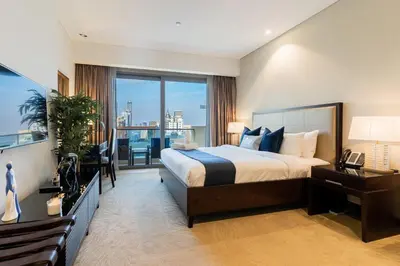 a bedroom with a large bed and a large window at The Classic in Dubai