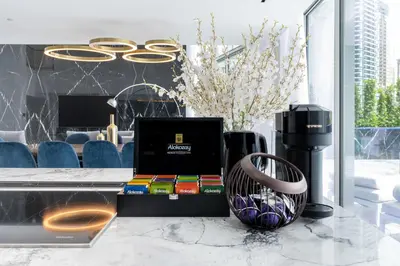 a desk with a laptop and books and a vase at Grand Dubai Marina 4BR Triplex with Pool Gym Sauna in Dubai