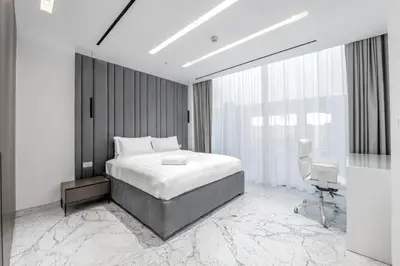 a bedroom with a bed and a desk in it at Grand Dubai Marina 4BR Triplex with Pool Gym Sauna in Dubai