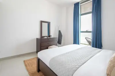 a bedroom with a bed and a mirror and a window at Frank Porter - Pulse C1 in Dubai