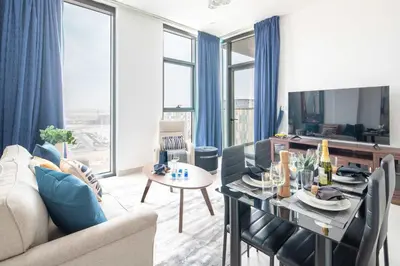 a living room with a table and a dining room at Frank Porter - Pulse C1 in Dubai