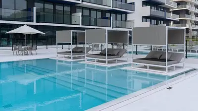 a swimming pool with two lounge chairs and a building at Sleek 1br Apt Jvc Quiet Space With Pool & Par in Dubai