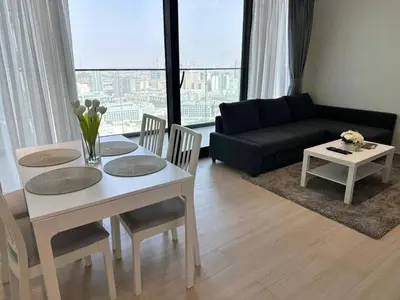 a living room with a table and a couch at Sleek 1br Apt Jvc Quiet Space With Pool & Par in Dubai