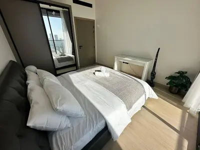 a bedroom with a white bed with a large mirror at Sleek 1br Apt Jvc Quiet Space With Pool & Par in Dubai