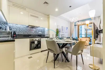 a kitchen and dining room with a table and chairs at Unbeatable Rate Modern 2BR with Partial Canal Views by Deluxe Holiday Homes in Dubai
