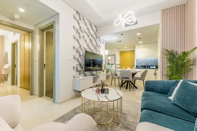 a living room with a blue couch and a table at Unbeatable Rate Modern 2BR with Partial Canal Views by Deluxe Holiday Homes in Dubai