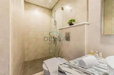 a bathroom with a shower and a toilet and a sink at Unbeatable Rate Modern 2BR with Partial Canal Views by Deluxe Holiday Homes in Dubai