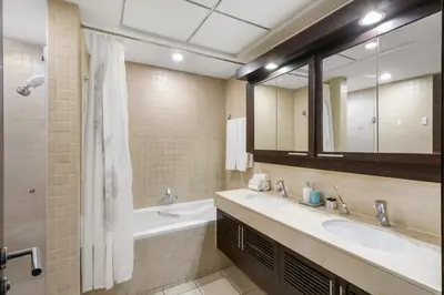 a bathroom with two sinks and a tub and a mirror at FIRST CLASS 2BR Burj Khalifa & Fountain View in Dubai