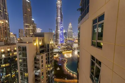 a view of a city at night with tall buildings at FIRST CLASS 2BR Burj Khalifa & Fountain View in Dubai