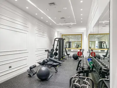 a gym with a row of treadmills and machines at FIRST CLASS 2BR Burj Khalifa & Fountain View in Dubai