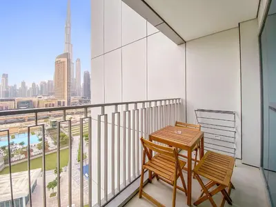 a balcony with a wooden table and two chairs at Silkhaus Deluxe 2BR in Downtown Views II in Dubai