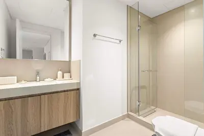 a bathroom with a shower and a sink and a toilet at Silkhaus Deluxe 2BR in Downtown Views II in Dubai
