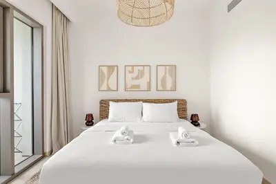 a bedroom with a white bed with two towels on it at Silkhaus Deluxe 2BR in Downtown Views II in Dubai