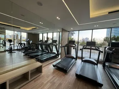 a gym with a bunch of treadmills and mirrors at ASHRI HH Spacious Apartment in JVC, Binghatti Luna in Dubai