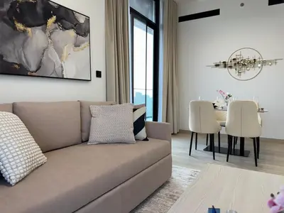 a living room with a couch and a table at ASHRI HH Spacious Apartment in JVC, Binghatti Luna in Dubai