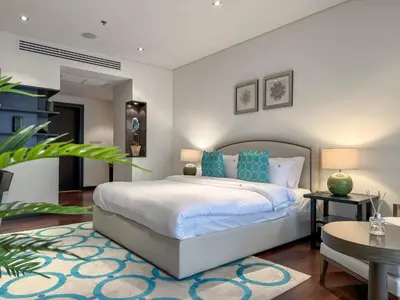 a bedroom with a large bed with blue pillows at Picture-Perfect 2BR apartment with Burj View in Dubai