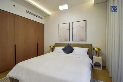 a bedroom with a white bed with two pictures on the wall at Luxury Escapes - Elegant 3 Bedroom plus Maids Room Apartment in JBR in Dubai