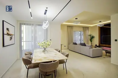 a living room with a table and a couch at Luxury Escapes - Elegant 3 Bedroom plus Maids Room Apartment in JBR in Dubai